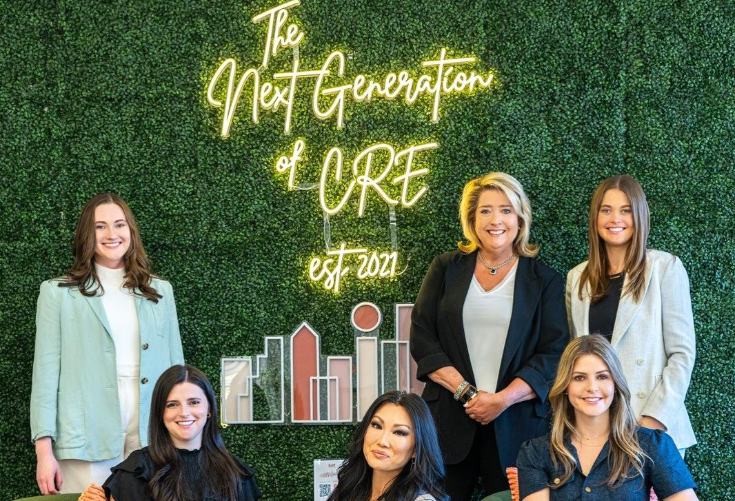Hart Commercial's Tanya Hart Little (standing, second from right) and Allison Johnston Frizzo (seated, far right) with their team