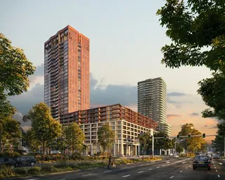 Tall residential buildings with modern architecture along a tree-lined street at sunset, with traffic lights and cars on the road.