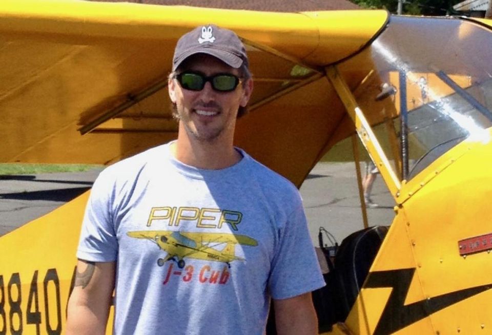RealtyMogul President Aaron Halfacre poses next to a plane.