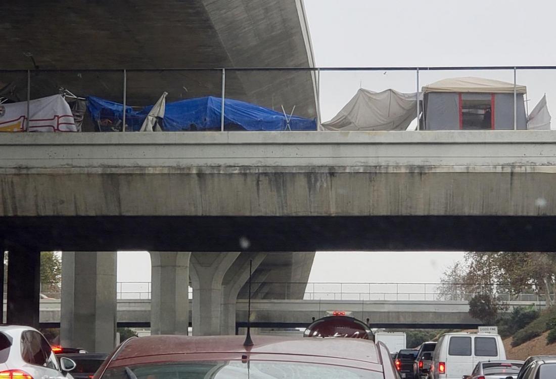Tent homes line a street above the I-110 freeway in South Los Angeles