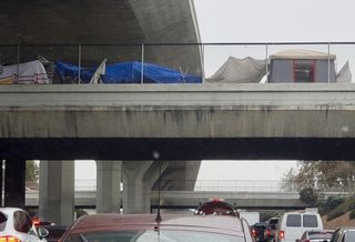 Tent homes line a street above the I-110 freeway in South Los Angeles