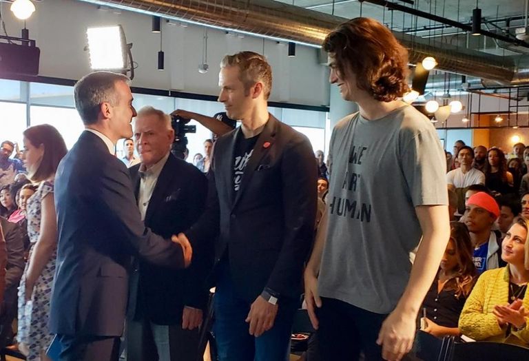 Los Angeles Mayor Eric Garcetti shakes WeWork's Jon Slavet's hand with WeWork Co-Founder Adam Neumann waiting at the WeWork Vine office in Hollywood.