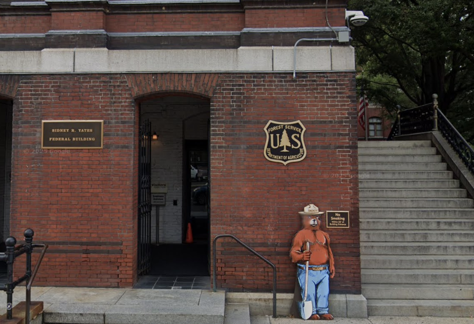 The exterior of the Sidney R. Yates Building, with a sign for the Forest Service and a bear cutout.