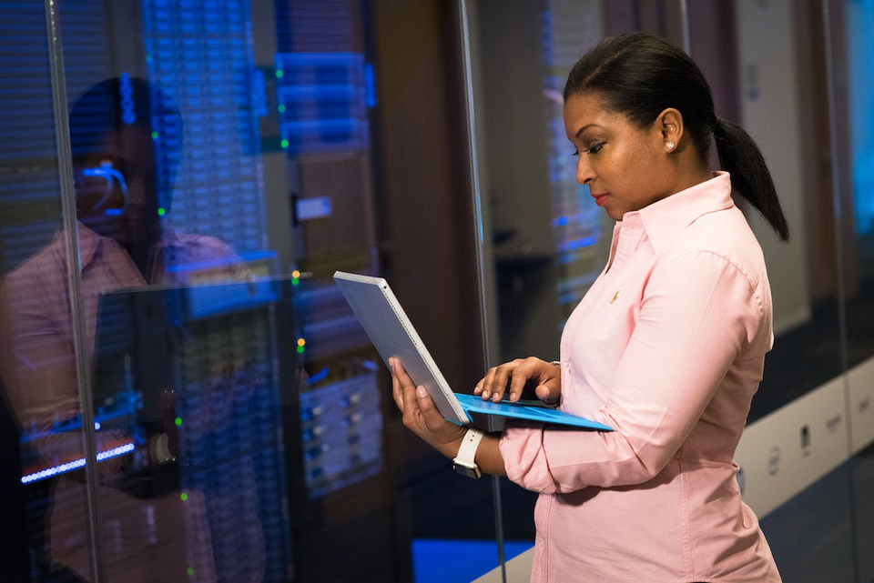 Software engineer with laptop at server racks