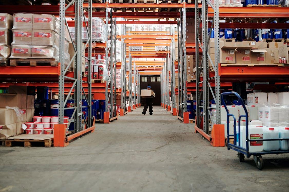 Guy carrying a box in a warehouse 