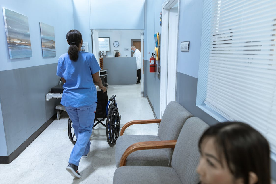 Nurse in a medical facility pushing a wheelchair