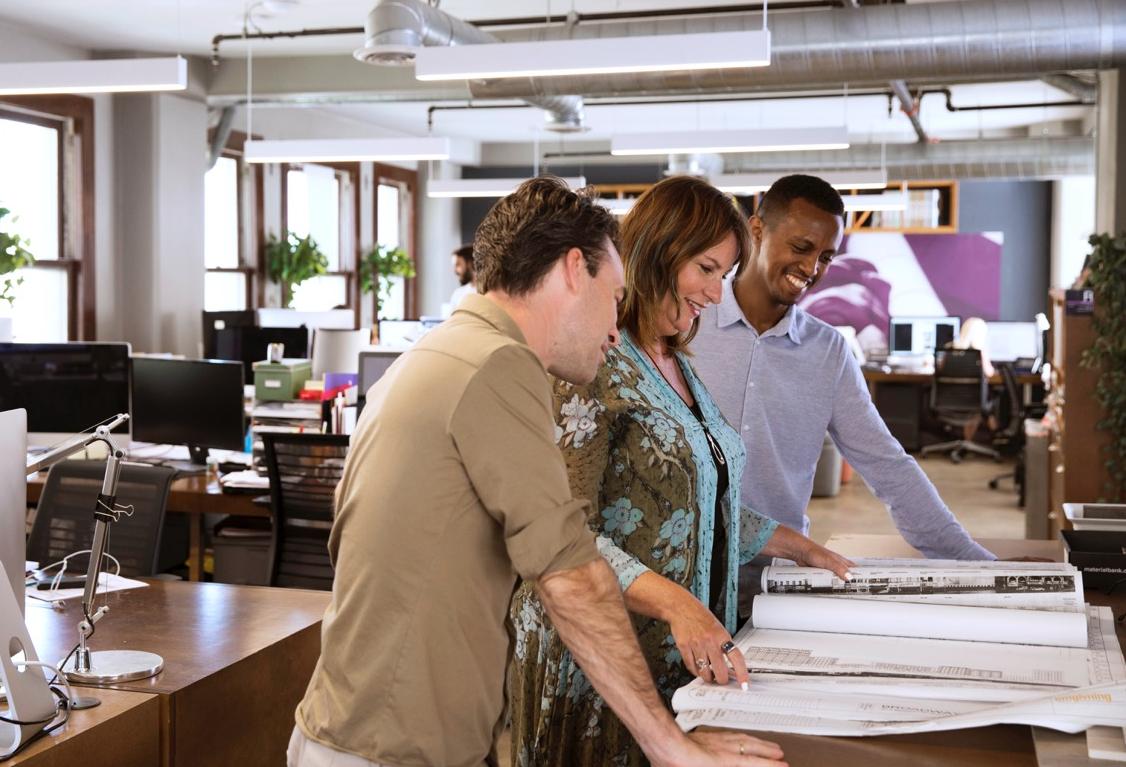 Omgivning Founder and Principal Karin Liljegren looks over design schematics with her team