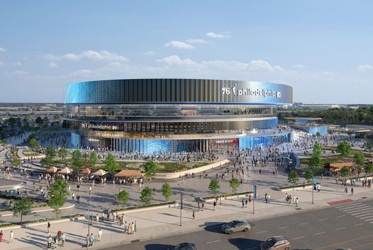 A modern, circular arena with a reflective facade and a bustling plaza, featuring people, cars, and greenery under a clear blue sky.