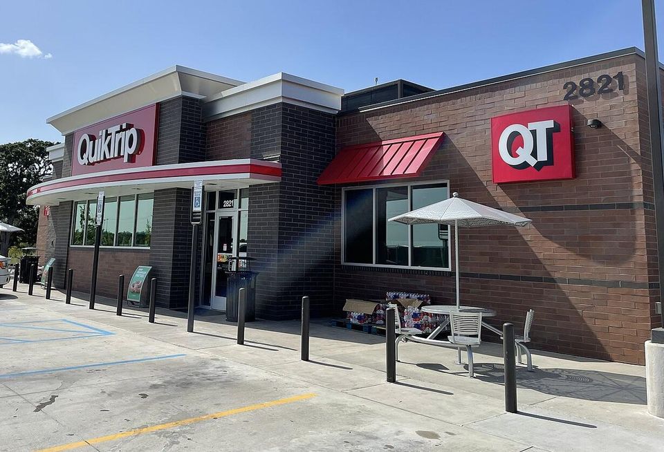 An image of a QuikTrip convenience store with red and white awning and brick facade.