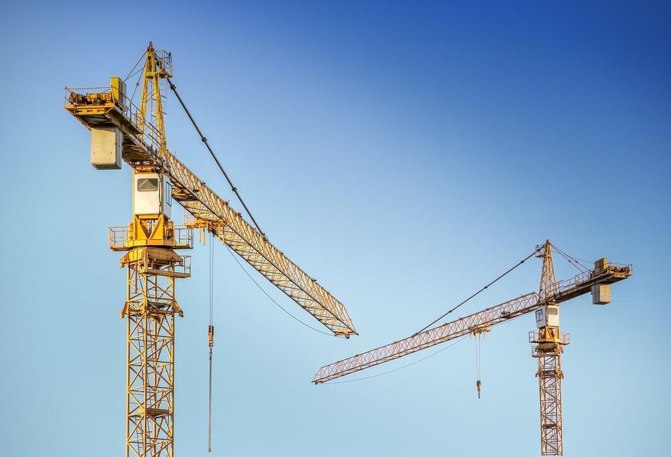 Construction cranes against a blue sky