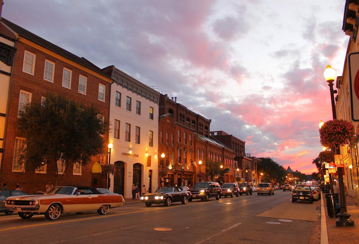 A street in Georgetown at sunset with vintage and modern cars on the road