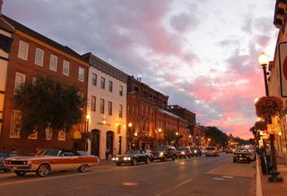 A street in Georgetown at sunset with vintage and modern cars on the road