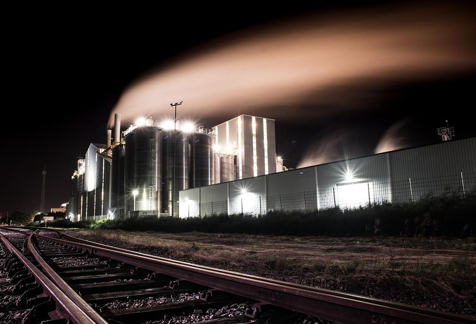 Smoke rising from a factory at night