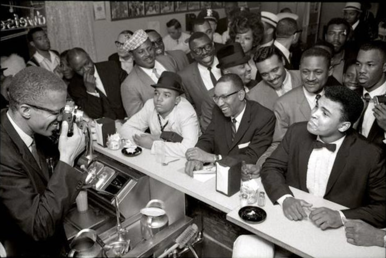 Malcolm X Photographs Muhammad Ali In February 1964 At Miami's Hampton House Hotel After Ali Had Defeated Sonny Liston.