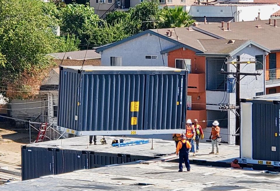 A crane lowers a modular unit on Hope on Alvarado, an 84-unit modular housing project for LA's chronically homeless, at 166 South Alvarado St. in Los Angeles.