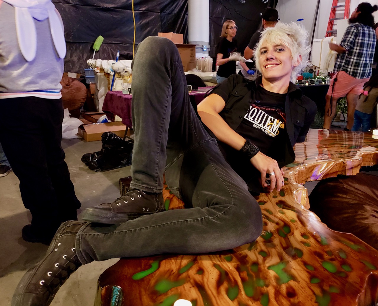 Owner Kris Irons lays on a table during a preview of Requiem: Coffee, Tea, and Fantasy in Anaheim.