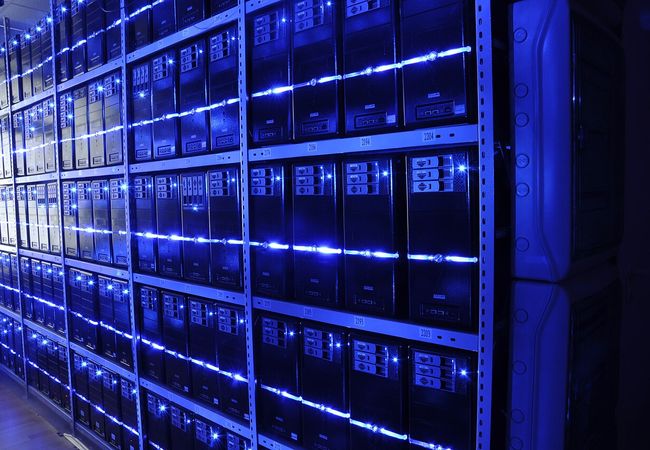 Racks of computer servers with glowing blue lights.