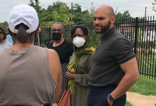 Council Member Robert White speaks to residents during a walkthough of ANC 8A