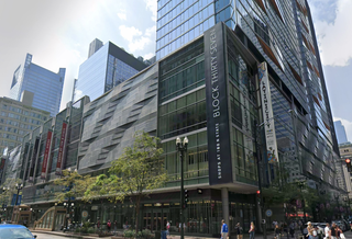 A modern multi-story glass and steel building, Block Thirty Seven, featuring retail and dining spaces, is located on a bustling city street.