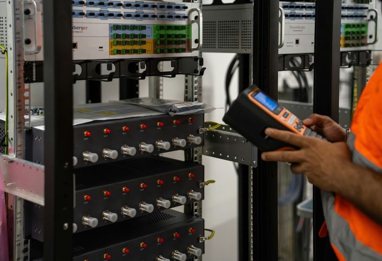 Person working at a rack in a data center.