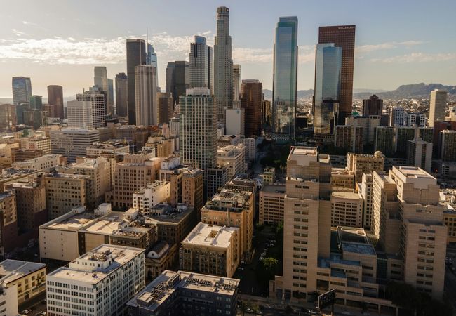 Aerial view of the Los Angeles skyline with skyscrapers under a clear blue sky.