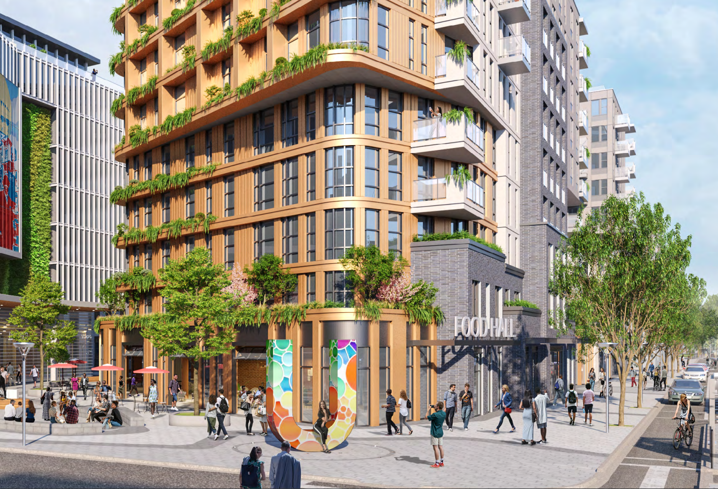 Street view of proposed development showing a food hall and public plaza with a prominent 'U' sign at center.