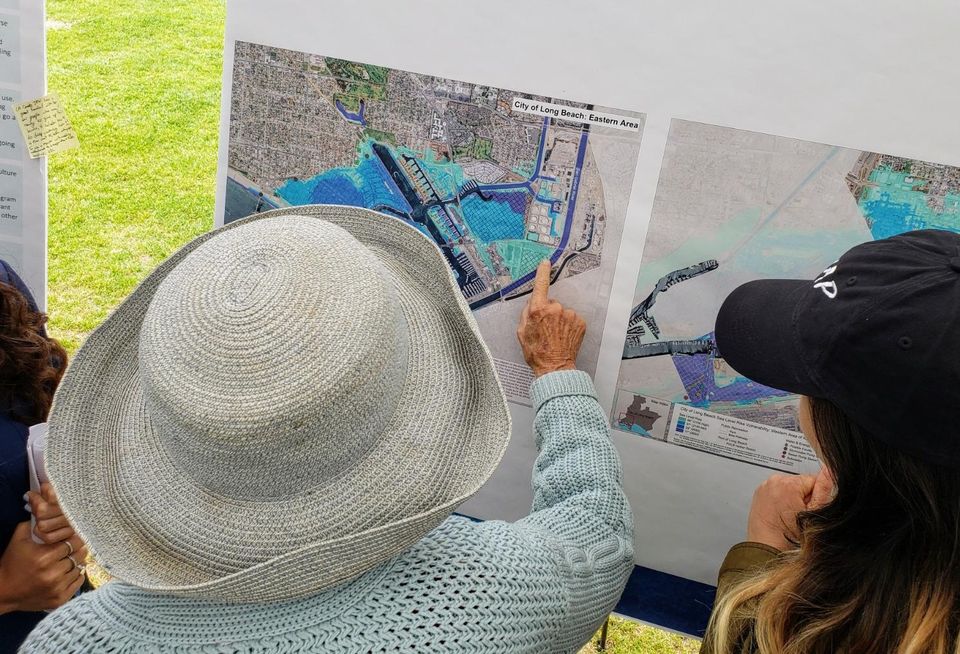A woman points at an area in the Naples neighborhood of Long Beach that could possibly be affected by sea level rise due to climate change during a climate fest in Long Beach.