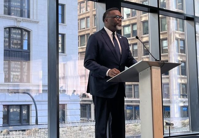 Chicago Mayor Brandon Johnson stands at a lectern.