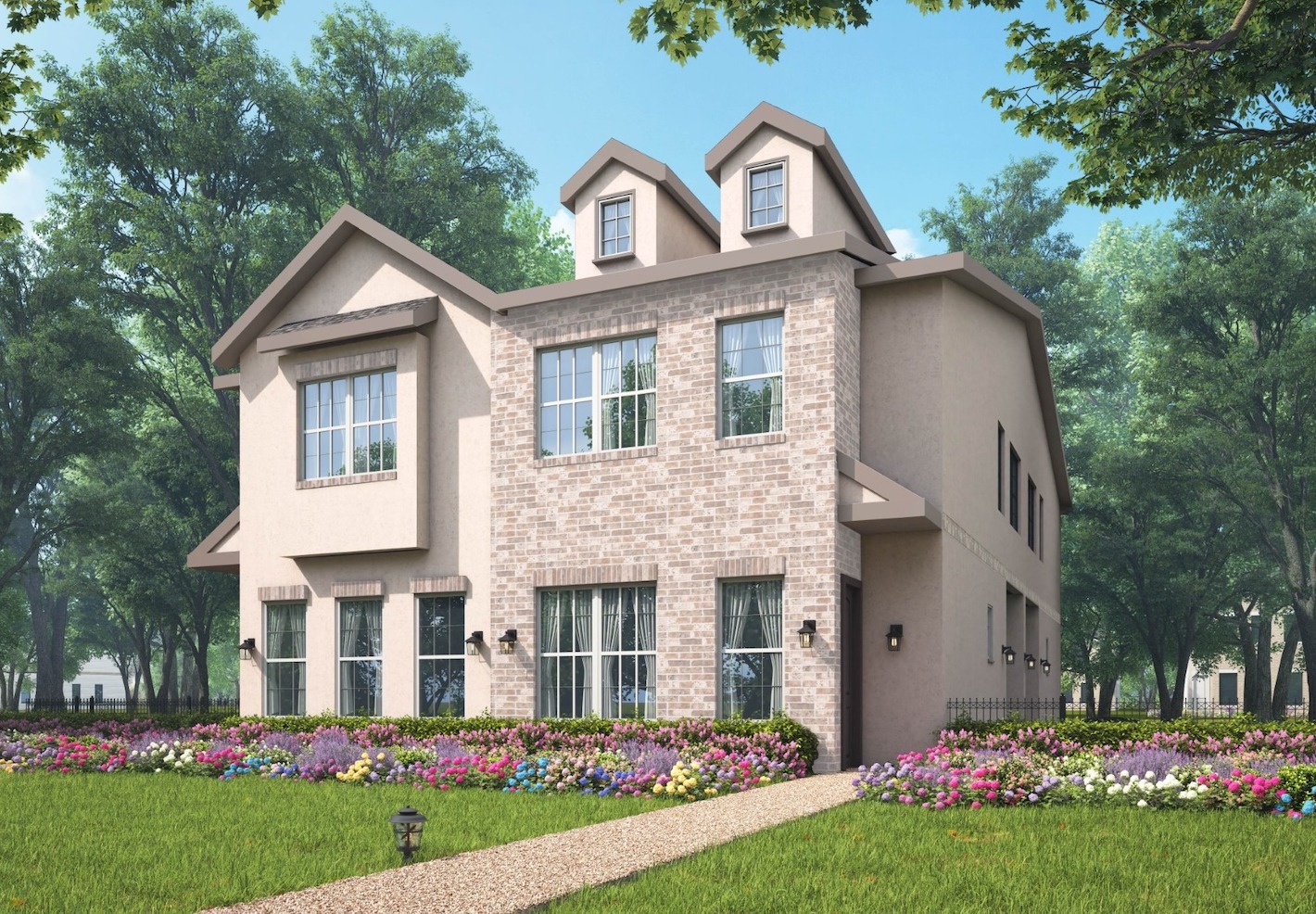 A modern two-story cottage with brick and stucco facade, surrounded by colorful flower beds and lush green trees under a clear blue sky.