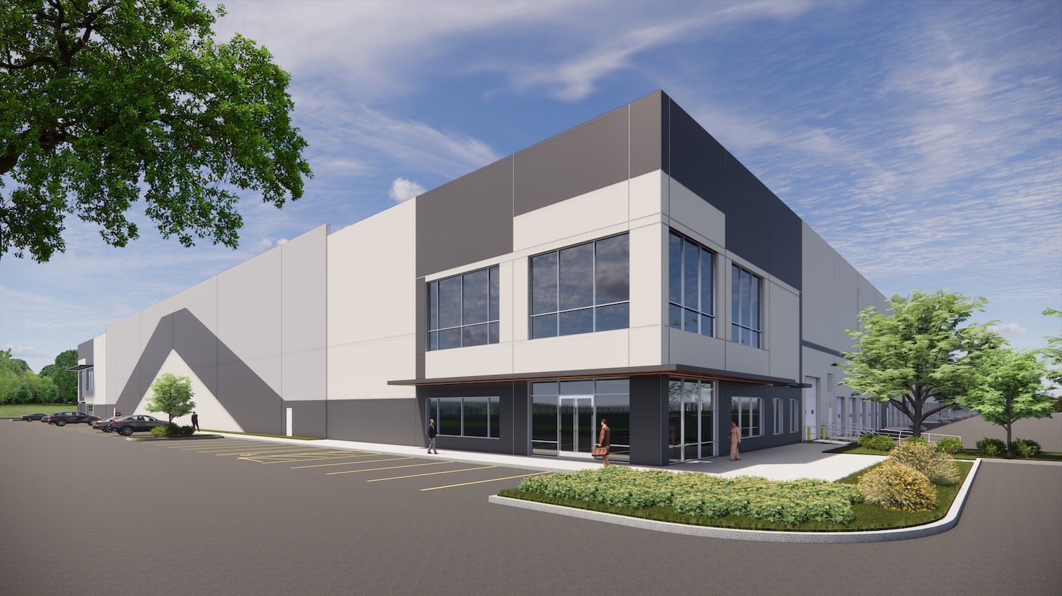 Modern industrial building with large windows, surrounded by a paved parking area and landscaped greenery under a partly cloudy sky.