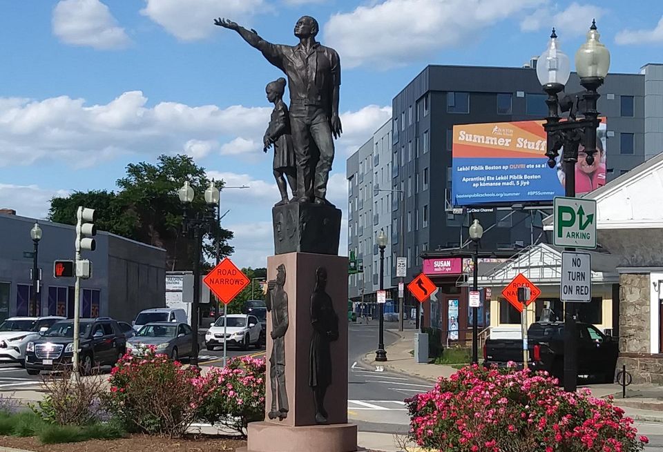 The Rise sculpture in Mattapan Square with The Loop at Mattapan Station (right) in the background.