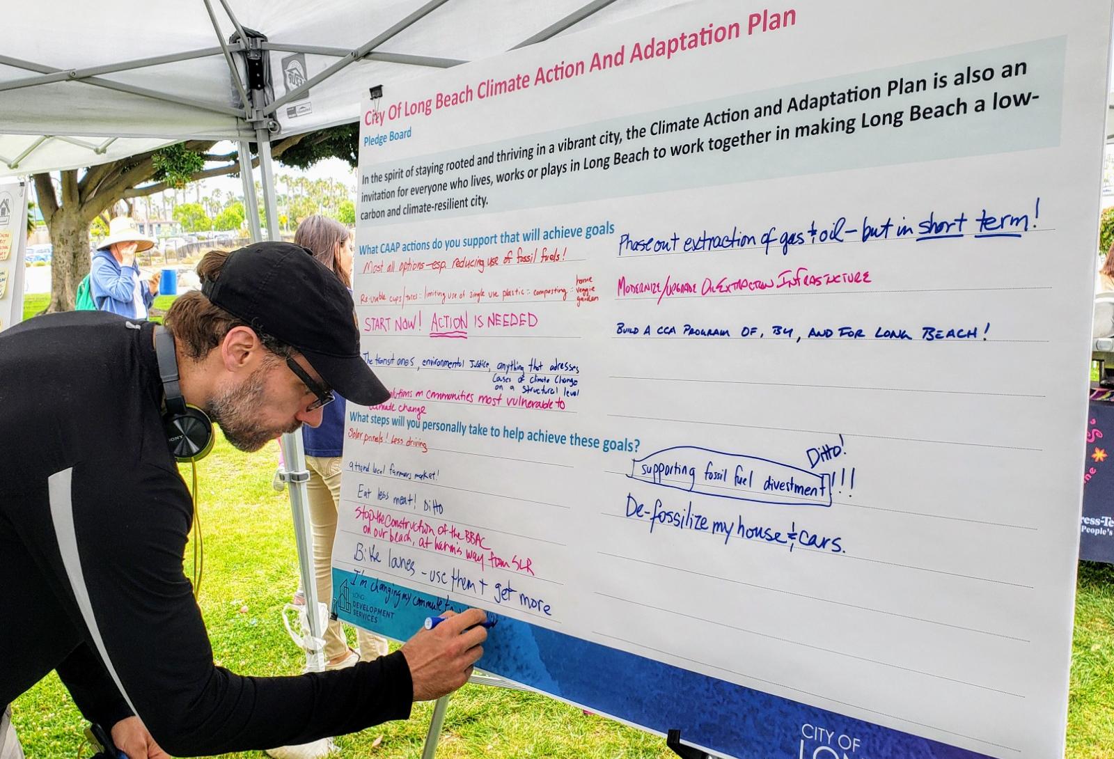 A resident writes down his suggestions on how the city of Long Beach can fight climate change during a climate fest event in Long Beach.