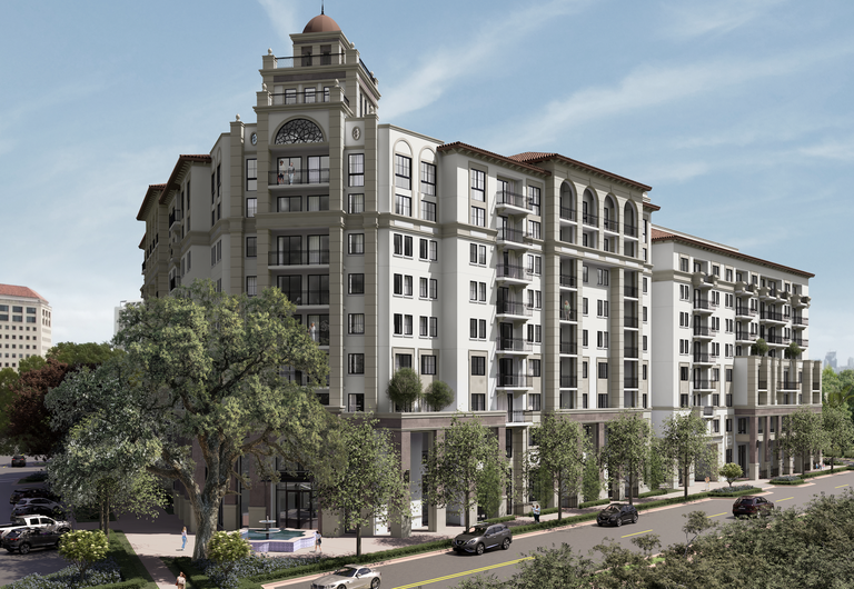 Large Mediterranean-style apartment building with balconies, tall arches, and lush trees lining the street under a clear blue sky.