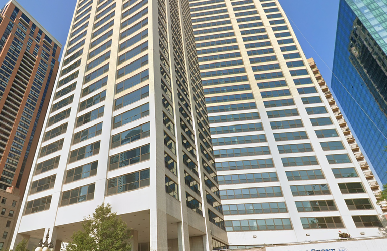 Tall modern high-rise buildingsset against a clear blue sky, with a massage and facial spa on the ground floor.