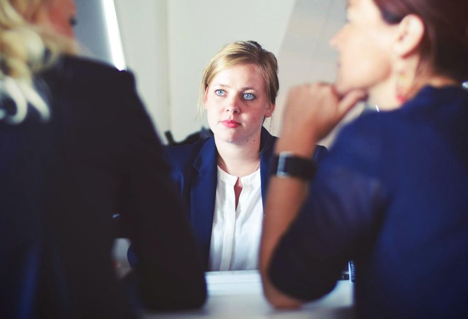 A job candidate listens to a pair of interviewers during a job interview