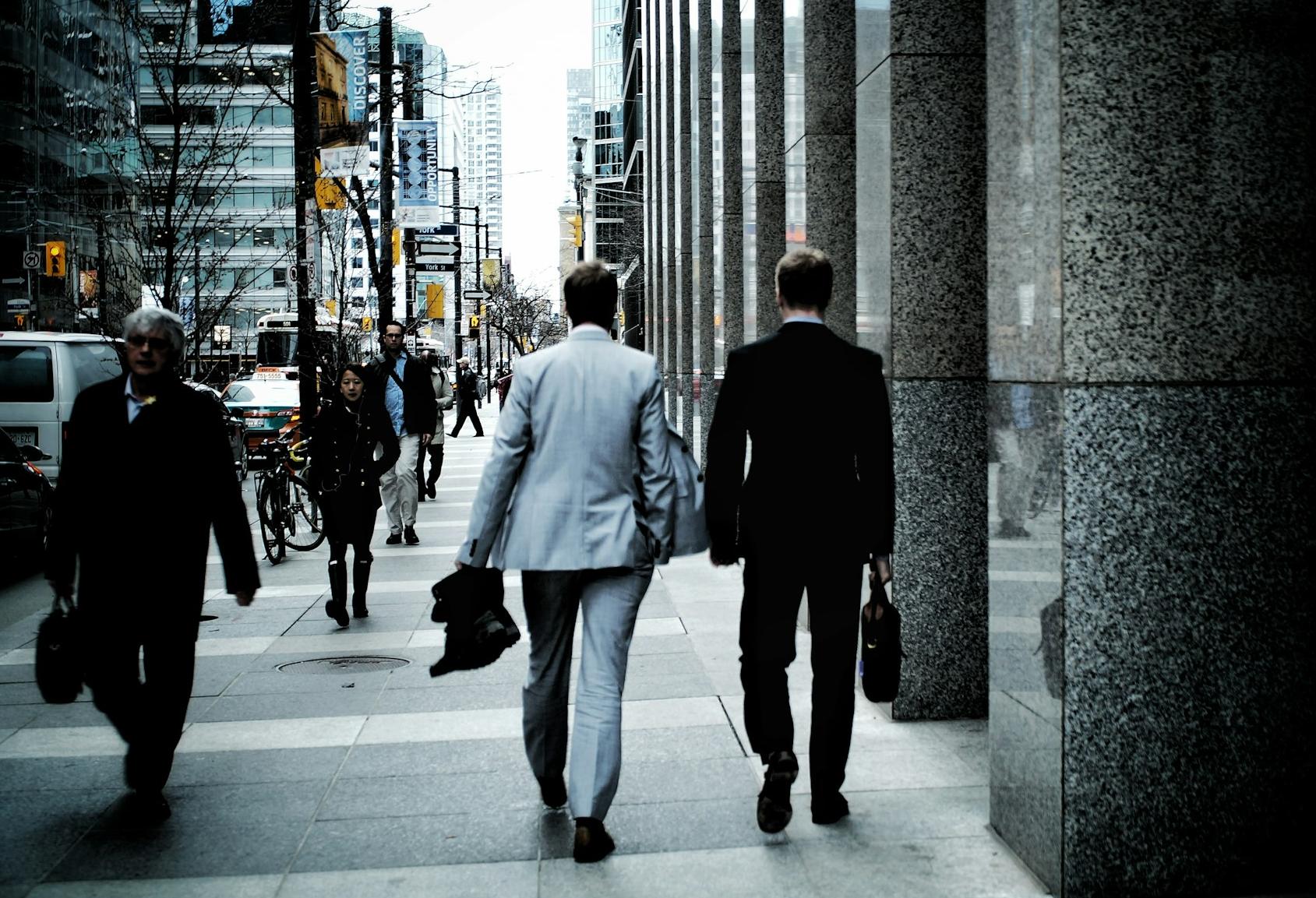 Men in suits walking through a city