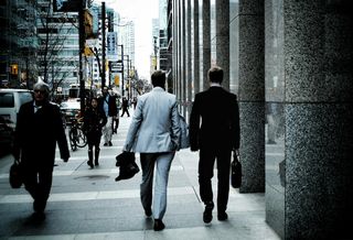 Men in suits walking through a city