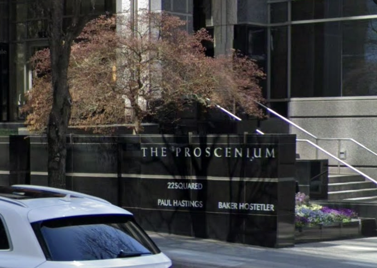 Exterior of The Proscenium building with signage for 22Squared, Paul Hastings, and Baker Hostetler. A tree and a white car are in the foreground.