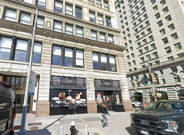 Street view of a multi-story building with STK restaurant signage on the ground floor, people walking, and vehicles parked nearby.