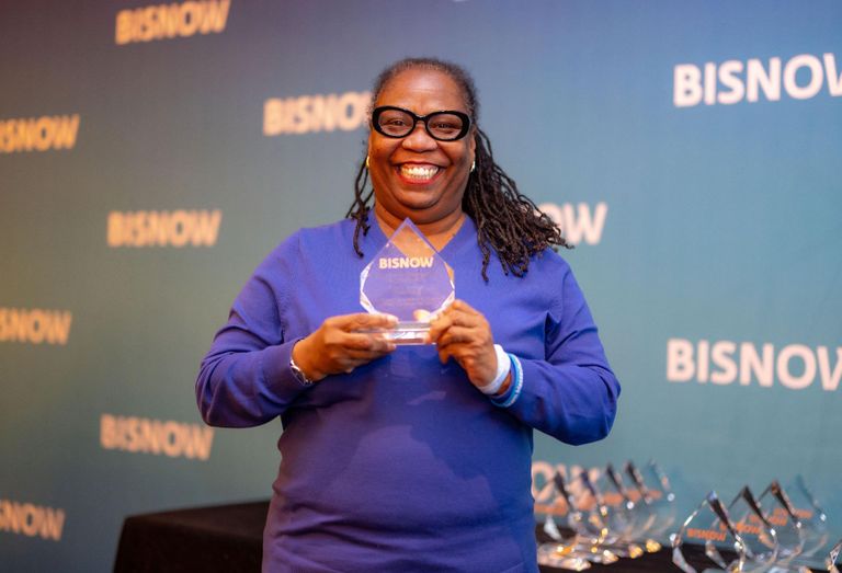 A smiling woman holding an award