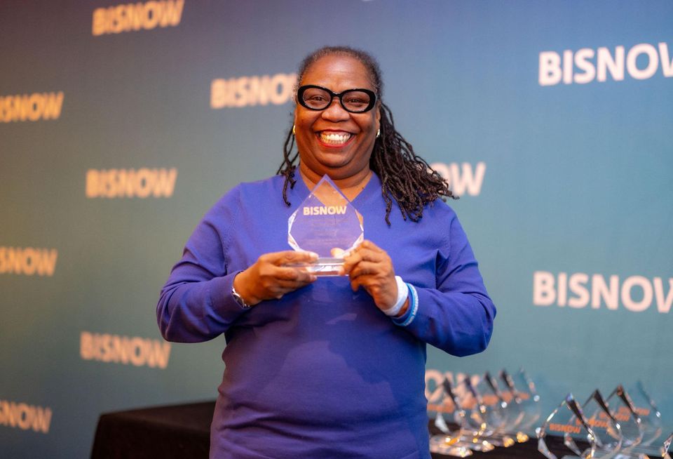 A smiling woman holding an award