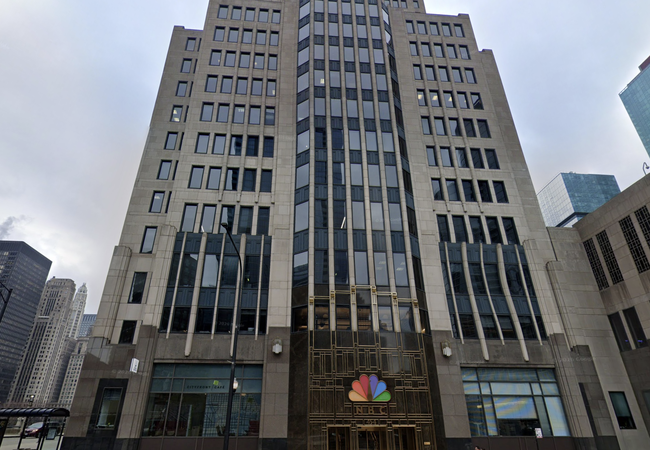 Tall Art Deco-style building with numerous windows, featuring the NBC logo above a grand entrance.