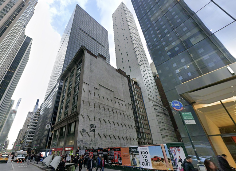 Street view of tall skyscrapers with a mix of modern and older buildings, bustling city life, taxis, and pedestrians in an urban setting.