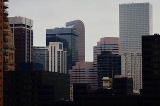 An image of the downtown Denver skyline on an overcast day with the cash-register building (Wells Fargo Center) at its center