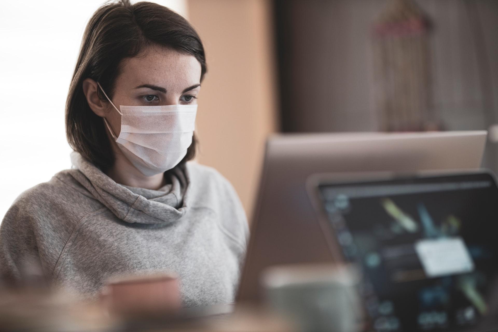 Woman at desk wearing mask