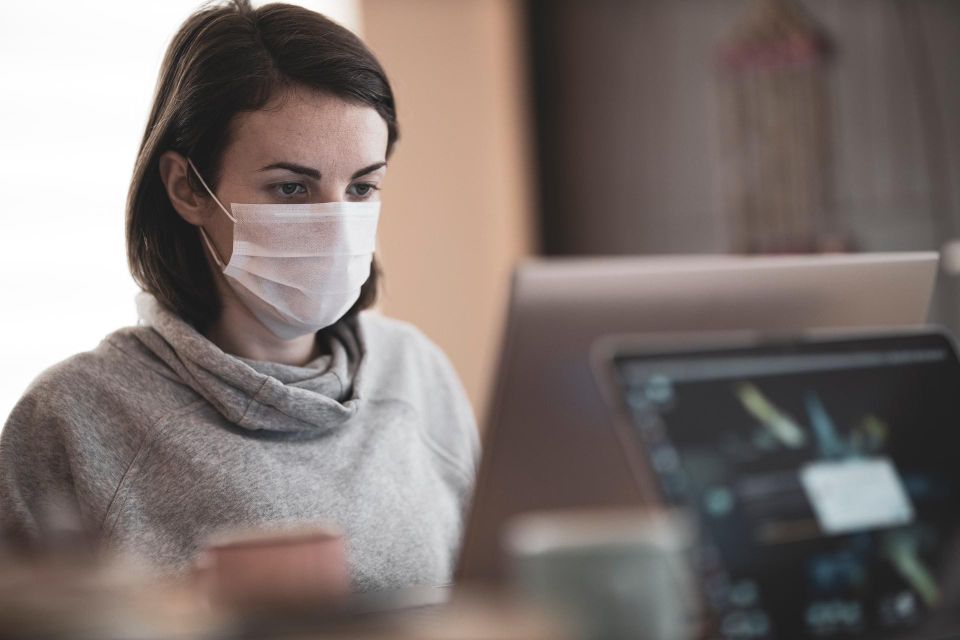 Woman at desk wearing mask