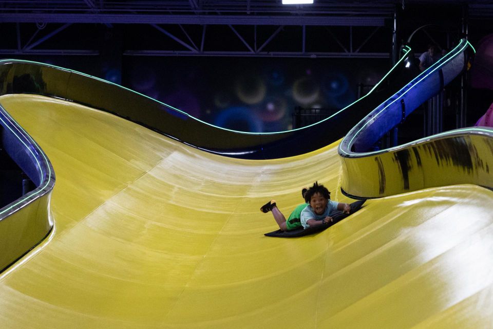 A small child on a big yellow slide