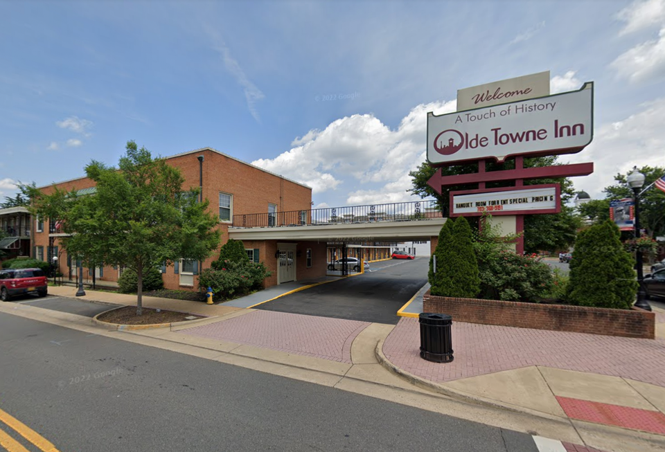 Welcome sign for Olde Towne Inn and two-story brick building with driveway
