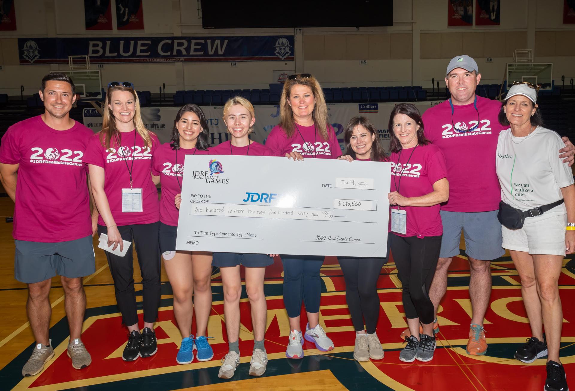 Organizers of the 2022 JDRF Real Estate Games present a check with this year's fundraising total, $613,560.