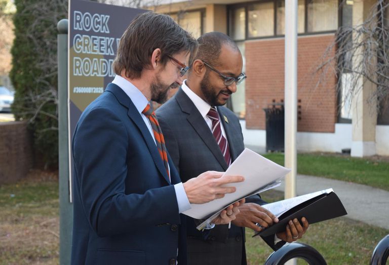 Office of Planning Director Andrew Trueblood and Hubbard flip through the Rock Creek West Roadmap.